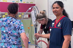 Three Peel Health Campus nurses prepare an item of equipment